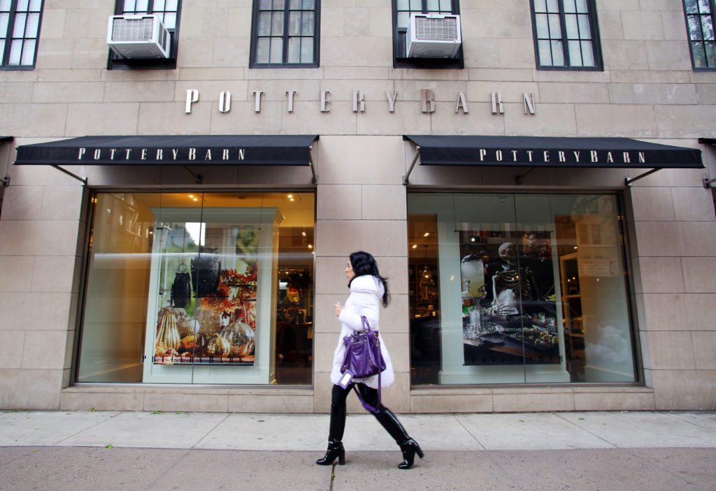 Woman walking past a Pottery Barn store in New York City